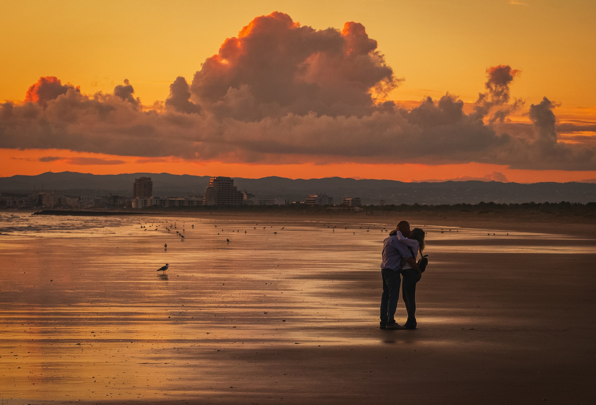 夕暮れの海岸で抱き合うカップル