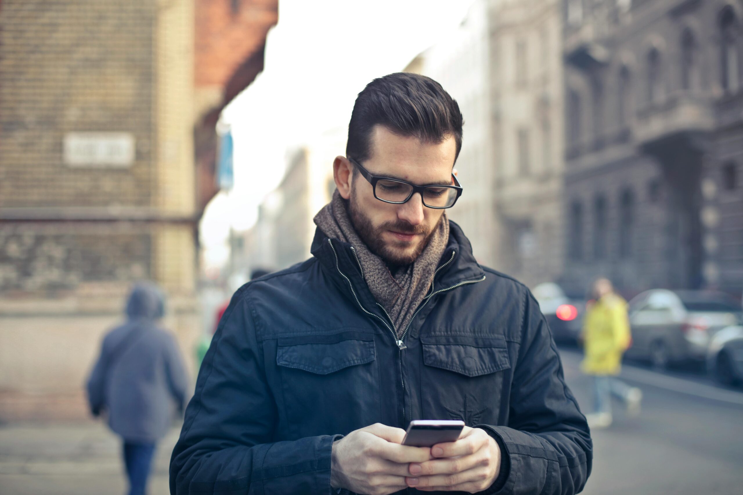 街中でスマホに目を落とす男性